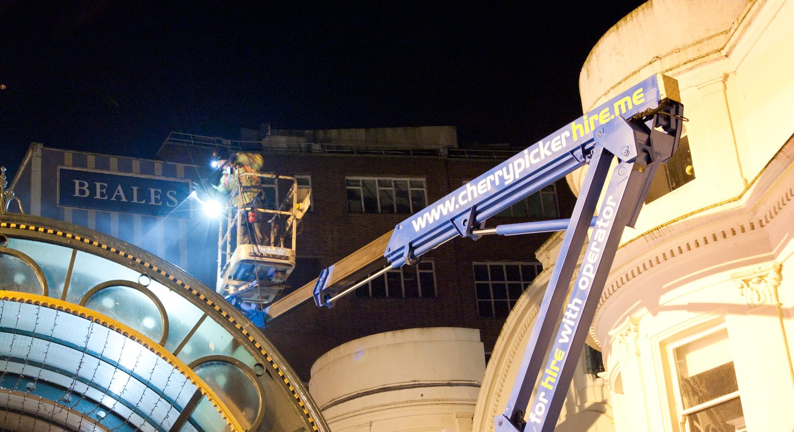 Truck-mounted cherry picker with its boom extended on a work site